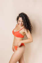 Load image into Gallery viewer, Girl in coral bikini set. scoop front bottoms with ruching in the back. Side shot