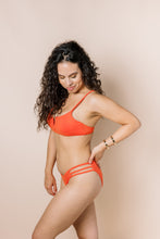 Load image into Gallery viewer, Girl in coral bikini set, full coverage bottoms side view
