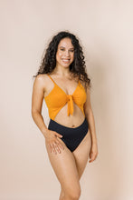Load image into Gallery viewer, Girl in colour block one piece bikini with cut out. Top is burnt orange and bottom is black. Front shot