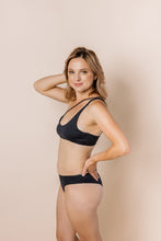 Load image into Gallery viewer, Girl in black bikini set. scoop front bottoms with ruching in the back. Side shot