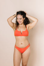 Load image into Gallery viewer, Girl in coral bikini set with scoop neck top with a V shape. Front shot
